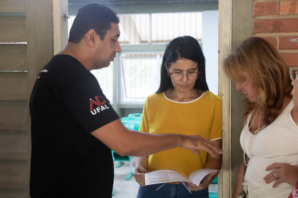 Presidente da Adufal apresentando o Portf&oacute;lio Jur&iacute;dico da entidade &agrave; professora no CTEC.
